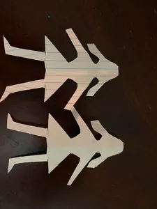 The same cut paper figures rearranged on the table, seen from another angle